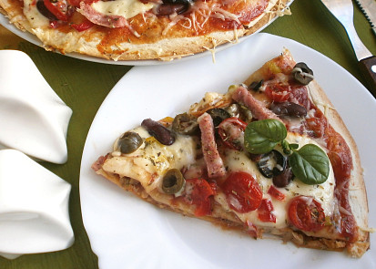 Tortilla jako pizza s mletým masem, mozzarellou a olivami